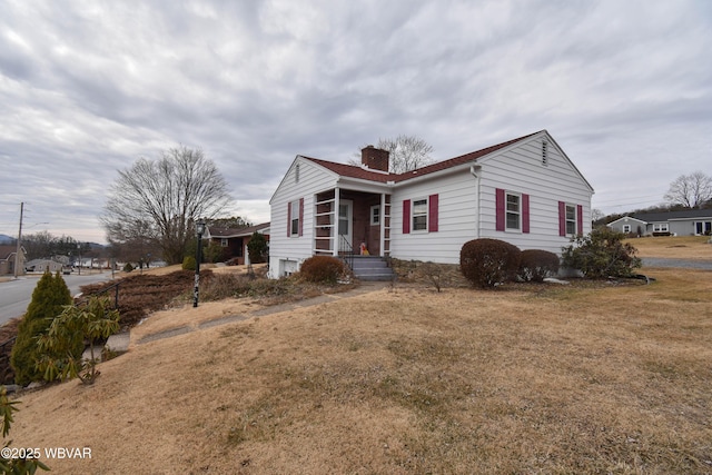 view of front of property with a chimney and a front yard