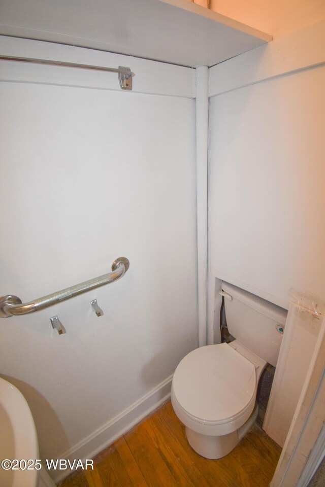 bathroom featuring baseboards, toilet, and wood finished floors