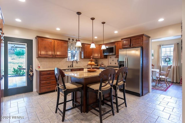 kitchen with a wealth of natural light, sink, appliances with stainless steel finishes, and tasteful backsplash