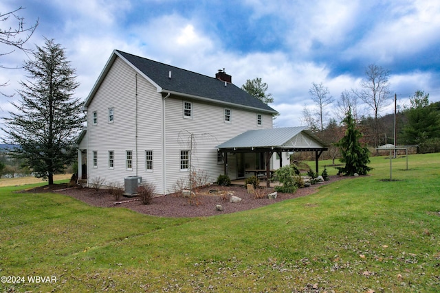 rear view of property featuring a patio area, a yard, and central AC