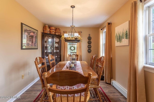 dining room with a baseboard radiator, plenty of natural light, and dark hardwood / wood-style floors