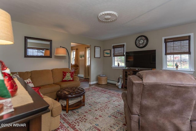 living room with baseboard heating and light wood-type flooring