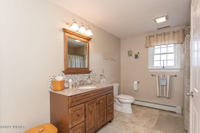 bathroom with vanity, toilet, baseboard heating, and tasteful backsplash