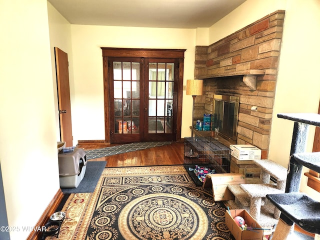 living area featuring baseboards, a fireplace, and wood finished floors