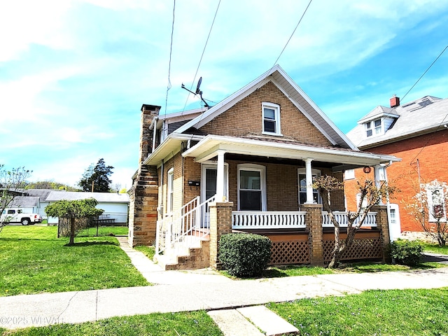 bungalow-style home featuring covered porch, brick siding, a chimney, and a front lawn