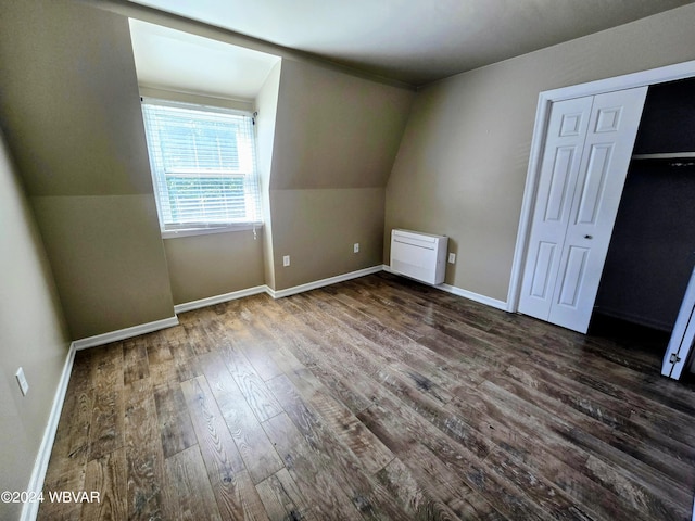 additional living space with dark wood-type flooring and lofted ceiling