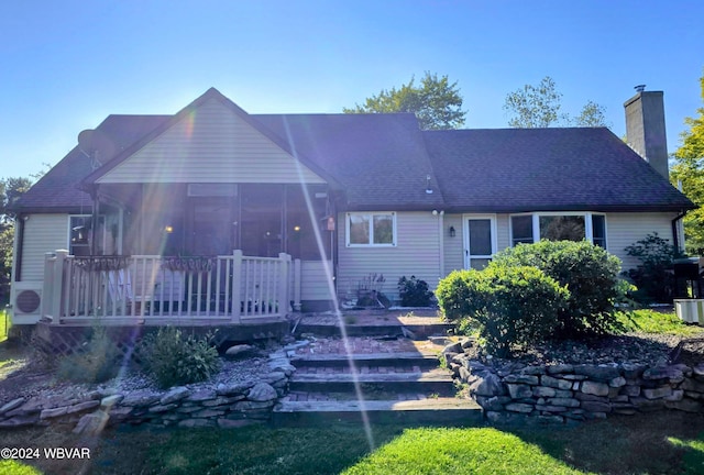 rear view of house featuring a sunroom