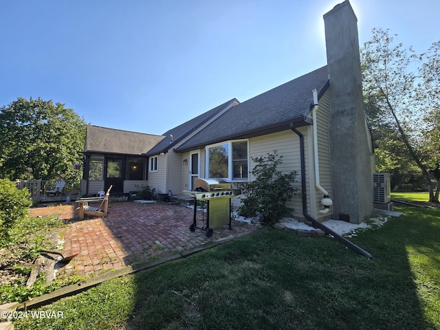 back of house featuring a lawn and a patio