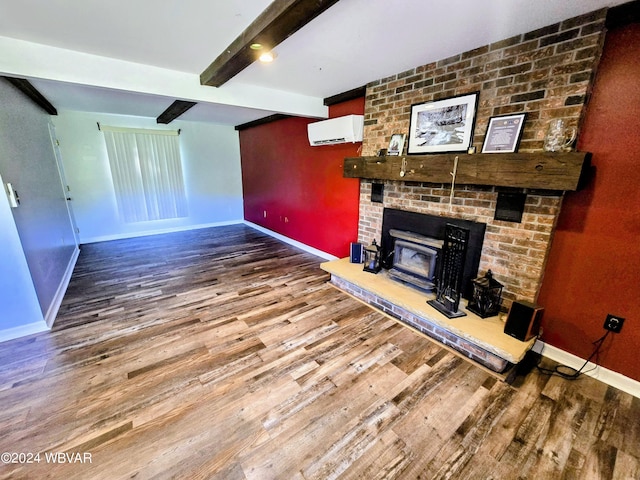 unfurnished living room with hardwood / wood-style flooring, beam ceiling, and an AC wall unit