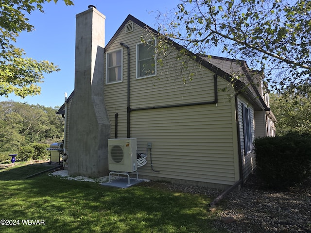 rear view of house featuring a lawn and ac unit