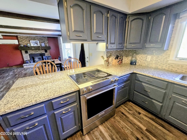 kitchen featuring kitchen peninsula, a fireplace, dark wood-type flooring, and stainless steel range oven