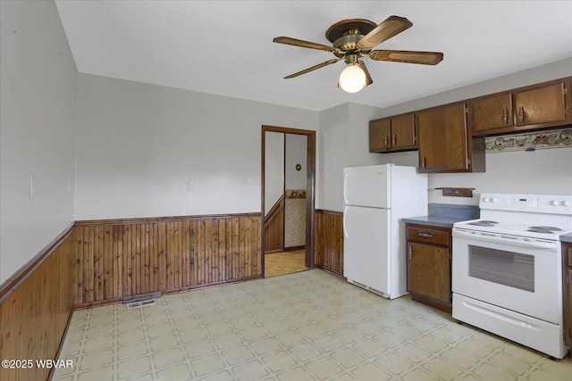6553 Jacks Hollow Rd, Williamsport, PA 17702 - kitchen with ceiling fan, a wainscoted wall, wooden walls, light floors, and white appliances