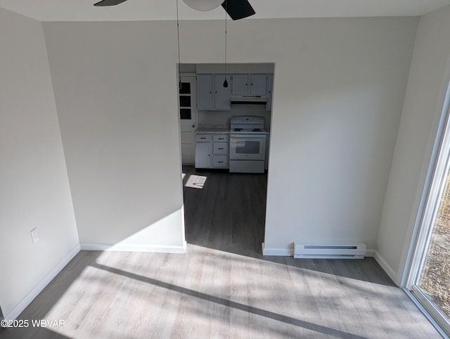 unfurnished room featuring a baseboard heating unit, hardwood / wood-style floors, and ceiling fan