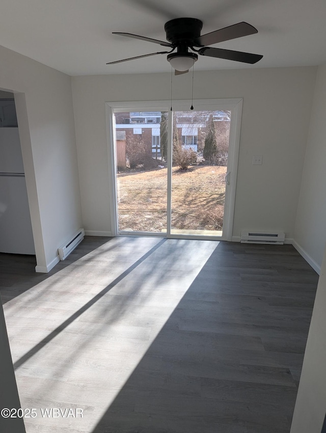 unfurnished room featuring dark wood-type flooring and a baseboard heating unit