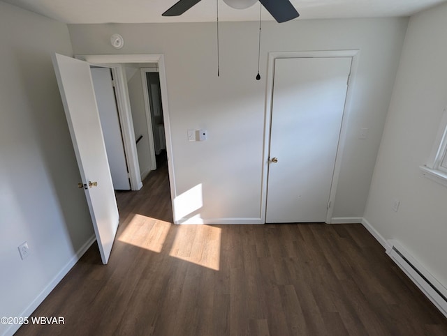 unfurnished bedroom featuring a baseboard radiator, dark hardwood / wood-style floors, ceiling fan, and a closet