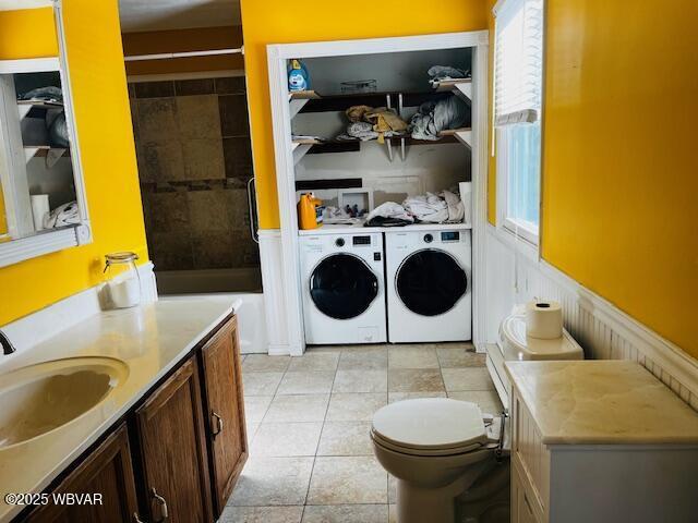 laundry room featuring sink, washer and dryer, and light tile patterned floors