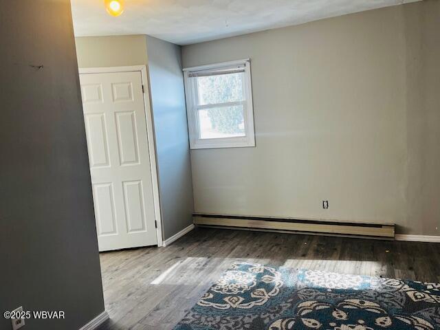 interior space with light wood-type flooring and a baseboard heating unit