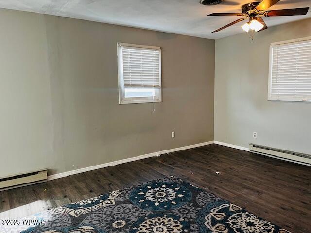 spare room with a baseboard radiator, dark hardwood / wood-style floors, and ceiling fan