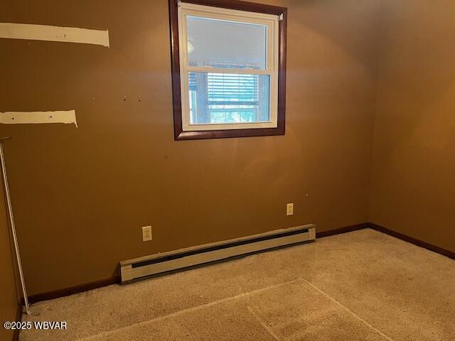 unfurnished room featuring a baseboard radiator and light colored carpet