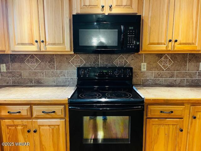 kitchen featuring tasteful backsplash and black appliances