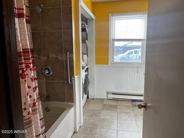 bathroom featuring washer / clothes dryer, a baseboard heating unit, and shower / tub combo with curtain