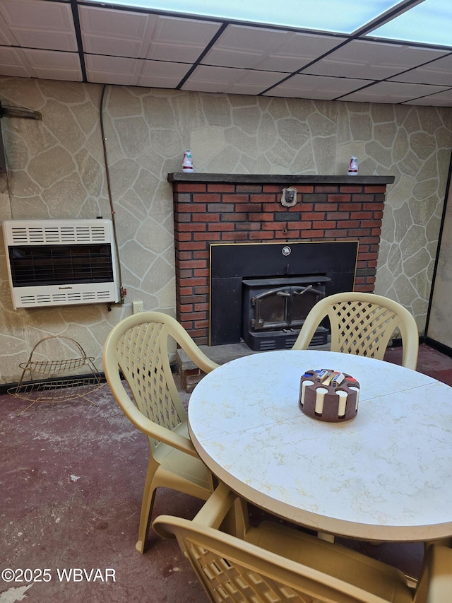 dining space featuring carpet, a wood stove, and heating unit