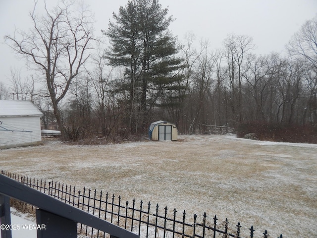 view of yard featuring fence, an outdoor structure, and a shed