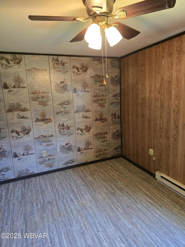 empty room featuring baseboard heating, ceiling fan, and wood finished floors