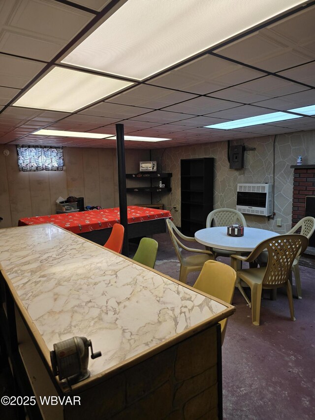 interior space featuring heating unit, a fireplace, carpet, and a drop ceiling
