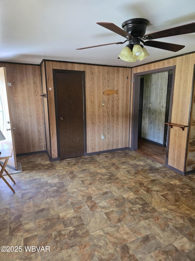 unfurnished bedroom with wood walls and baseboards