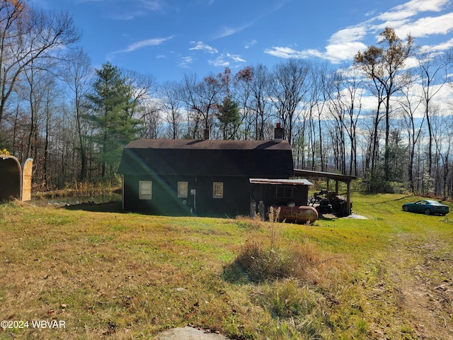 view of home's exterior with a carport and a lawn