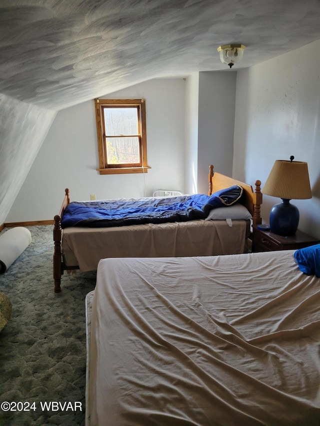 bedroom featuring dark carpet and vaulted ceiling