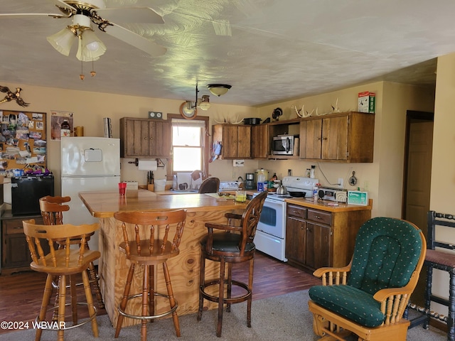 kitchen featuring ceiling fan, dark hardwood / wood-style flooring, and white appliances