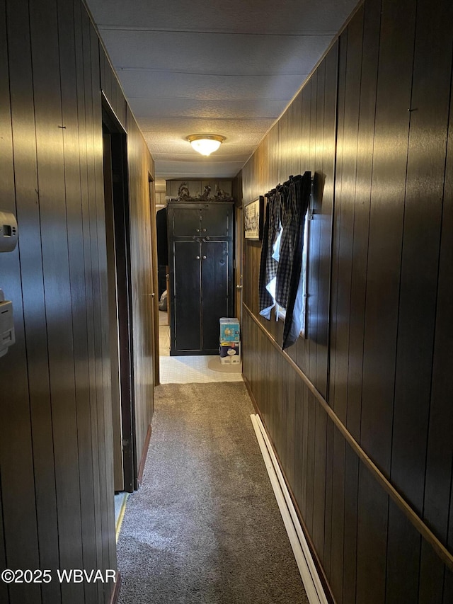 hall with light colored carpet and wooden walls