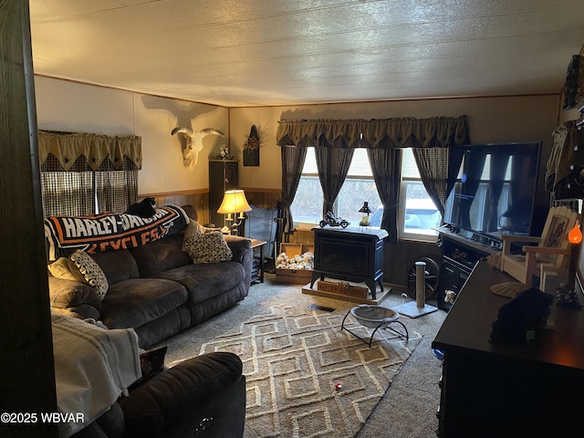 carpeted living area with a wainscoted wall and wooden walls