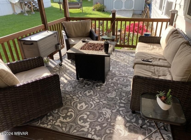 wooden terrace with a lawn and an outdoor living space with a fire pit