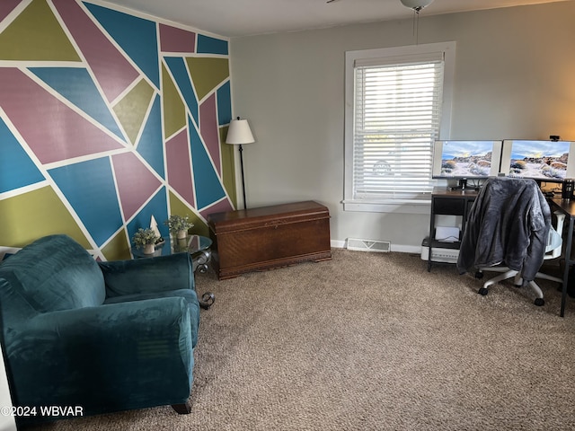 living area with ceiling fan and carpet