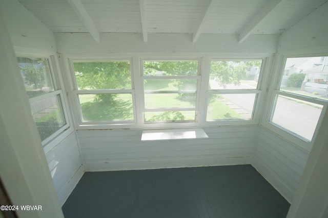 unfurnished sunroom featuring wood ceiling, plenty of natural light, and lofted ceiling with beams