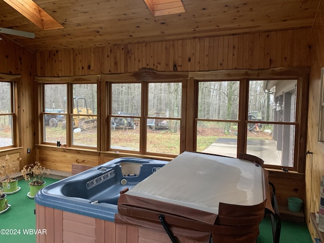 sunroom with wooden ceiling, a wealth of natural light, and a hot tub