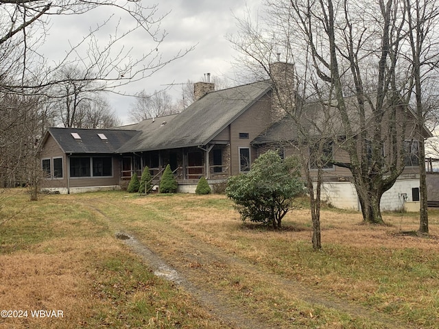 rear view of house featuring a lawn