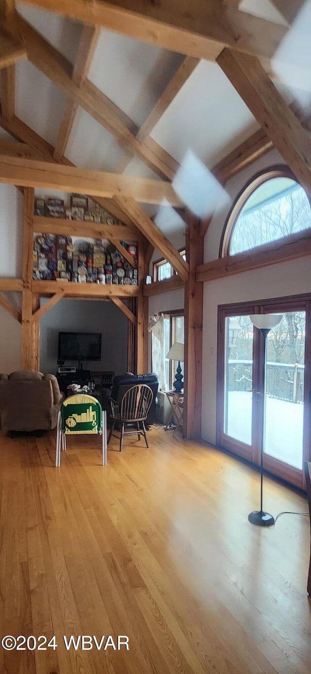 interior space with wood-type flooring, high vaulted ceiling, and beam ceiling