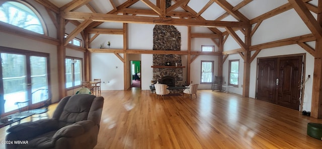 unfurnished living room featuring a fireplace, hardwood / wood-style floors, and high vaulted ceiling