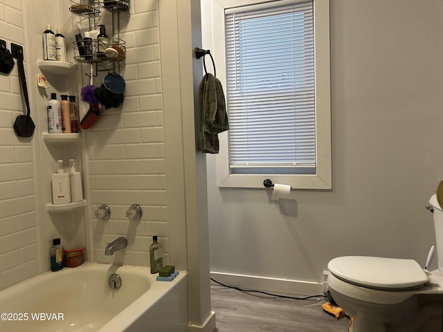 bathroom featuring hardwood / wood-style floors, a bathing tub, and toilet