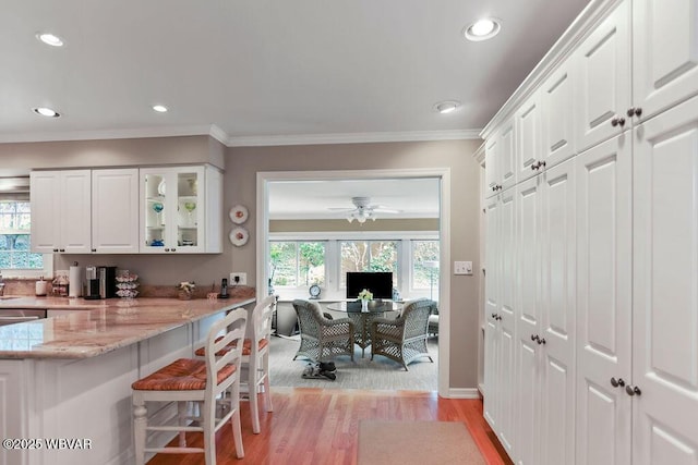 2528 N Hills Dr, Williamsport, PA 17701 - kitchen featuring light stone countertops, a healthy amount of sunlight, glass insert cabinets, and white cabinets