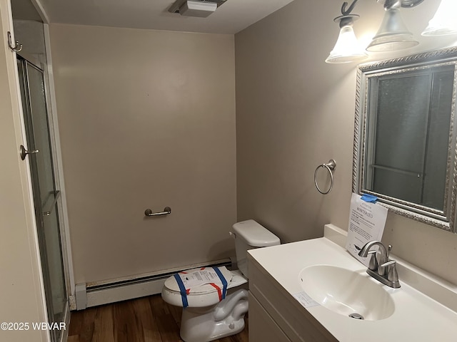 full bathroom featuring toilet, an enclosed shower, baseboard heating, wood finished floors, and vanity