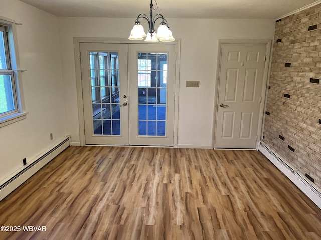 doorway with a baseboard radiator, a chandelier, and plenty of natural light