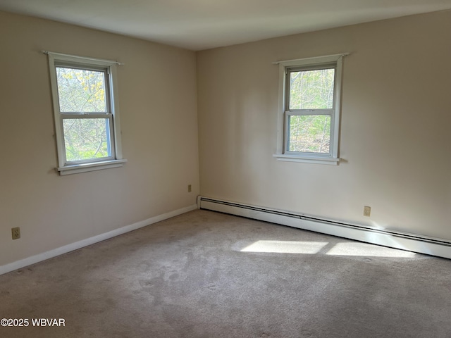 empty room featuring a baseboard heating unit, carpet, baseboards, and a wealth of natural light