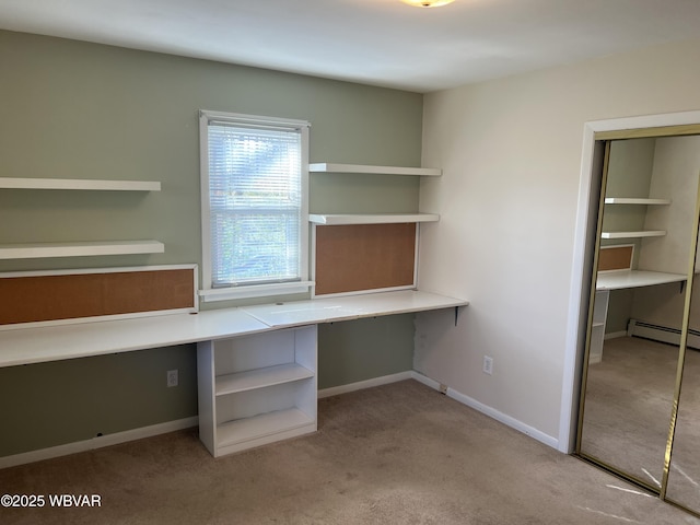 unfurnished office with baseboards, built in study area, carpet, and a baseboard radiator