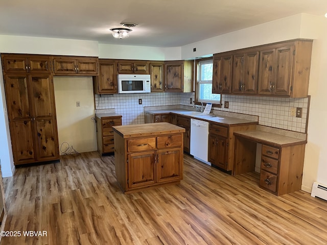 kitchen with backsplash, light wood-type flooring, a center island, and white appliances