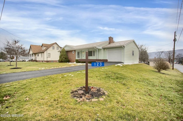 single story home with a garage and a front lawn